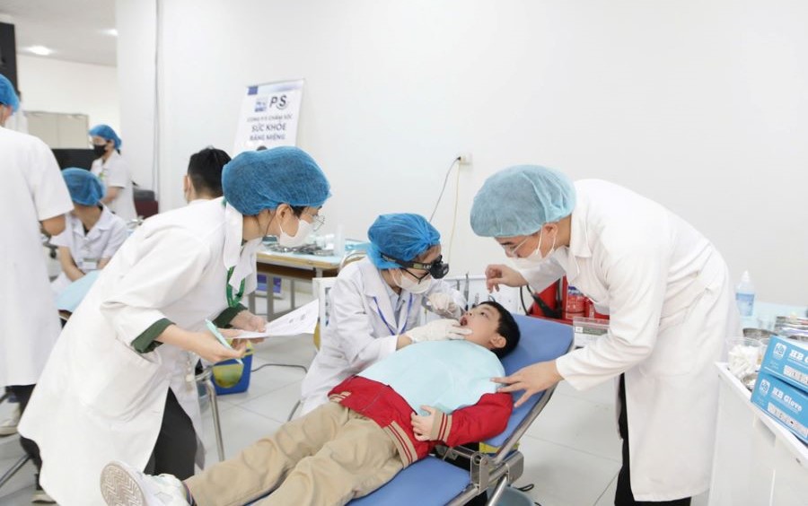 Các y, bác sĩ chăm sóc sức khỏe răng miệng miễn phí cho học sinh Trường Tiểu học Quang Trung (quận Hoàn Kiếm).