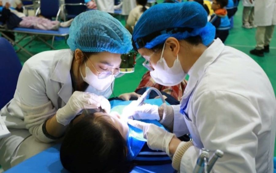 Các y, bác sĩ Bệnh viện Hữu nghị Việt Nam - Cu Ba đang tiến hành điều trị răng cho học sinh.